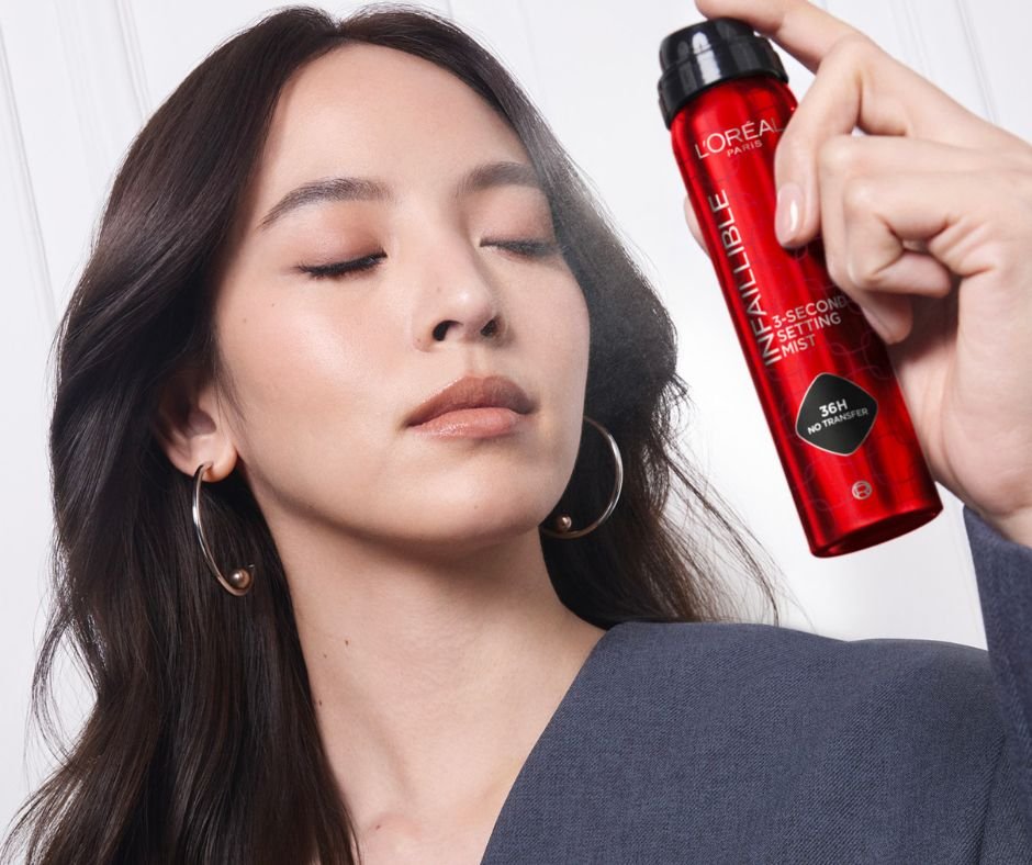 Mujer aplicando fijador de maquillaje en el rostro
